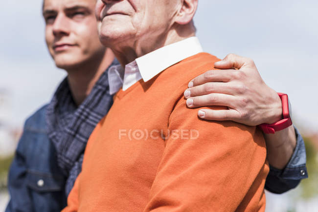 Старший чоловік і онук сидять на відкритому повітрі — стокове фото