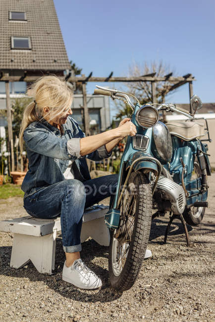 Женщина чистка мотоцикла — стоковое фото