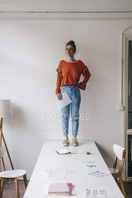 Frau steht mit Designschablonen auf Tisch — Stockfoto