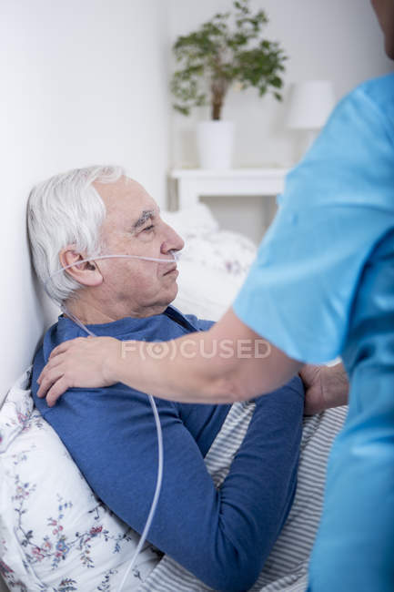 Enfermera ayudando al paciente con tubos nasales - foto de stock