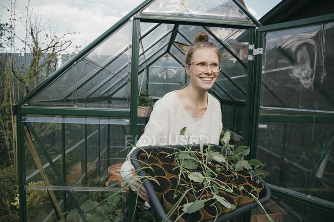 Young woman with potted seedlings — Stock Photo