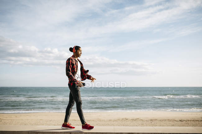Junger Mann spaziert am Strand — Stockfoto