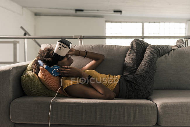 Woman on couch with VR glasses — Stock Photo