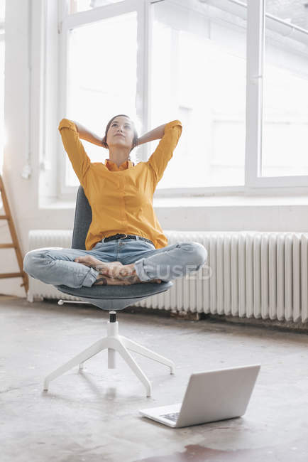 Frau sitzt mit Laptop in neuer Wohnung — Stockfoto