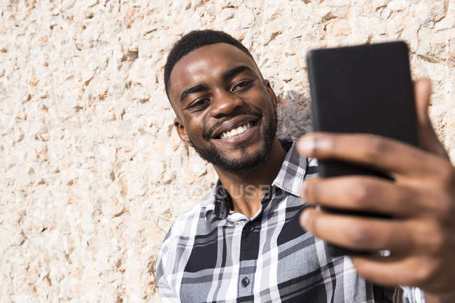 Усміхаючись молодий чоловік, беручи selfie — стокове фото