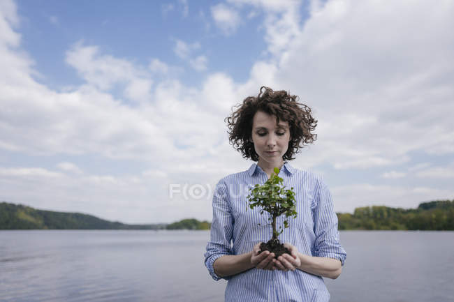 Frau am See hält Bäumchen — Stockfoto