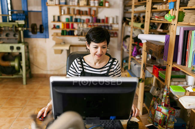 Schuhmacher mit Computer — Stockfoto