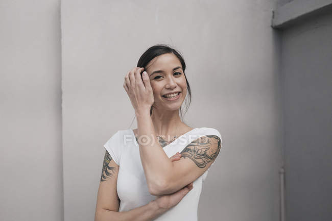 Портрет молодої жінки з татуюваннями, посміхаючись — стокове фото