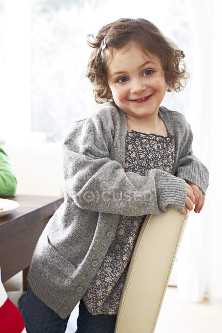 Дівчина на колінах на стільці в домашніх умовах — стокове фото