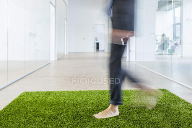 Geschäftsmann läuft auf Rasenteppich — Stockfoto