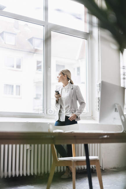 Geschäftsfrau schaut aus dem Fenster — Stockfoto