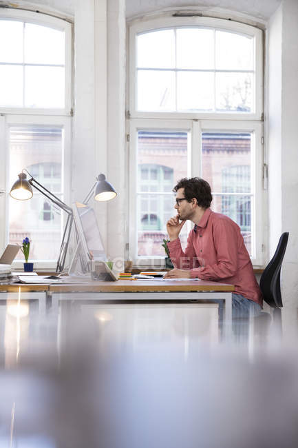 Mann sitzt am Schreibtisch — Stockfoto