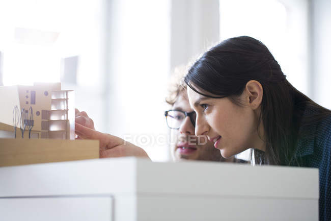 Mann und Frau diskutieren architektonisches Modell — Stockfoto