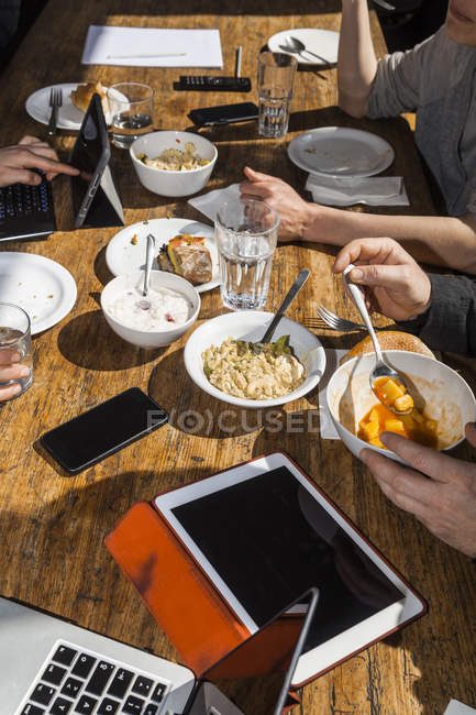 Kollegen beim gemeinsamen Mittagessen im Büro, Teilsicht — Stockfoto