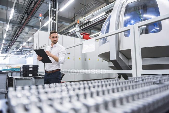 Man taking notes in factory — Stock Photo