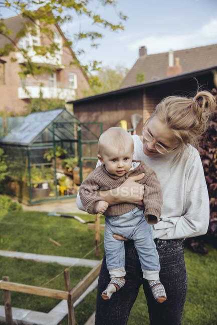 Baby boy with mother in garden — Stock Photo