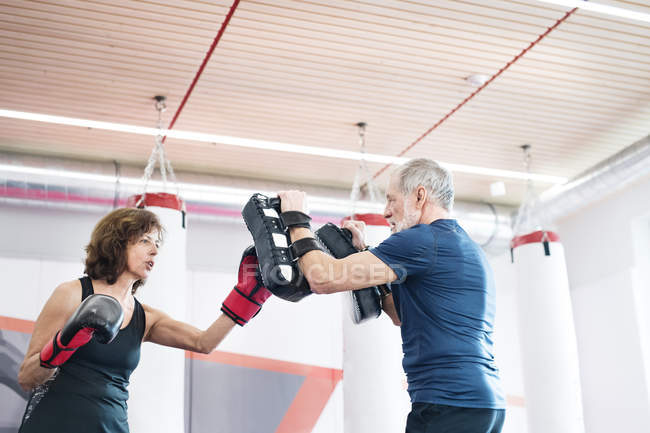 Mujer mayor boxeo con entrenador - foto de stock