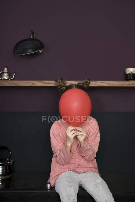 Chica escondida detrás del globo - foto de stock