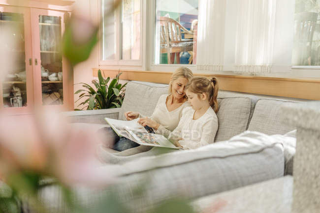 Woman and girl watching photo album — Stock Photo