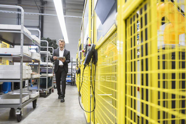 Mann benutzt digitales Tablet in Fabrik — Stockfoto