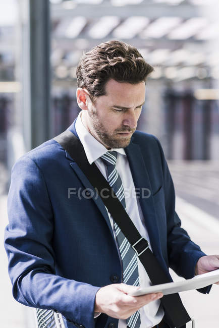 Hombre de negocios leyendo en tableta digital - foto de stock