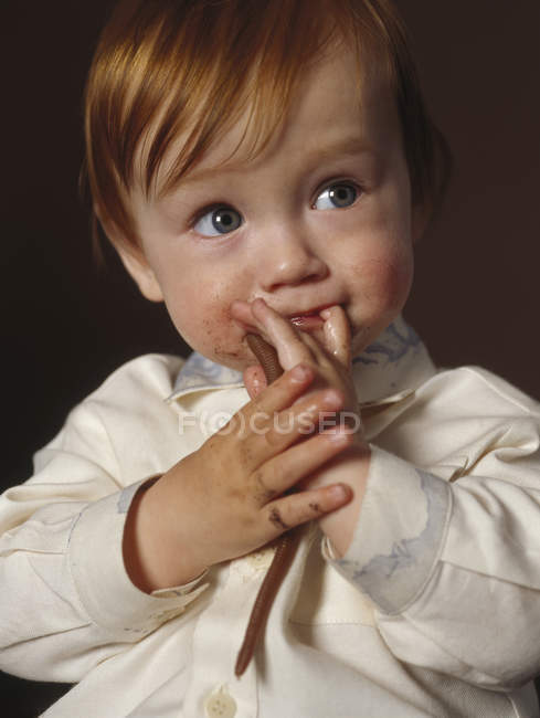 Bébé garçon tenant jouet ver — Photo de stock