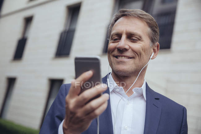 Businessman with earphones and smartphone — Stock Photo