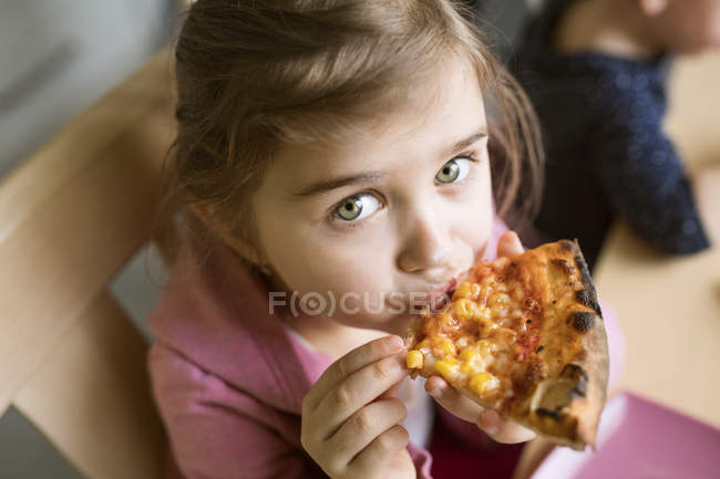 Retrato de niña comiendo pizza - foto de stock