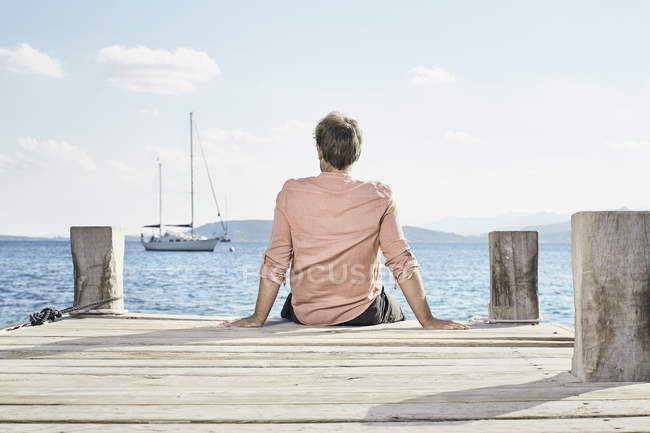 Man sitting on jetty — Stock Photo