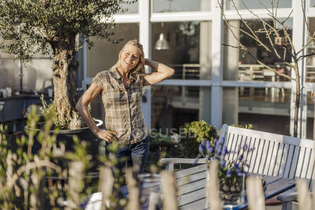 Mulher de pé no jardim com a mão na cabeça — Fotografia de Stock