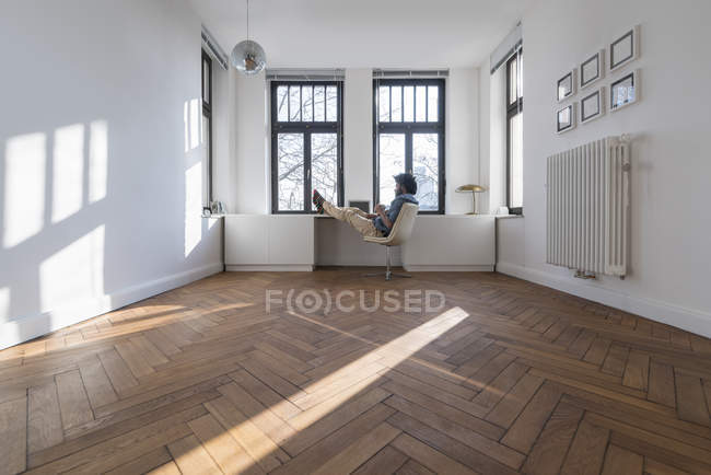 Man sitting in minimalist empty room — Stock Photo