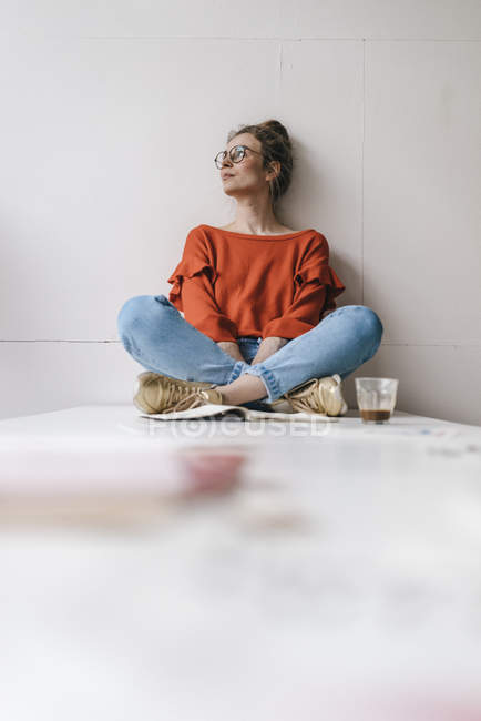 Femme assise sur la table pensant — Photo de stock
