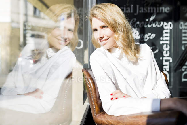 Femme dans le café regardant par la fenêtre — Photo de stock