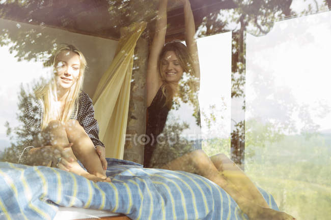 Meninas sentadas à janela — Fotografia de Stock