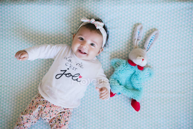 Bebé niña con juguete conejito - foto de stock