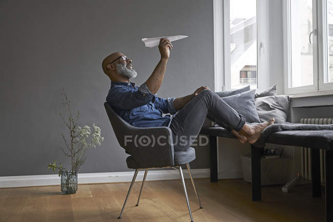 Зрелый человек с бумажным самолетом — стоковое фото