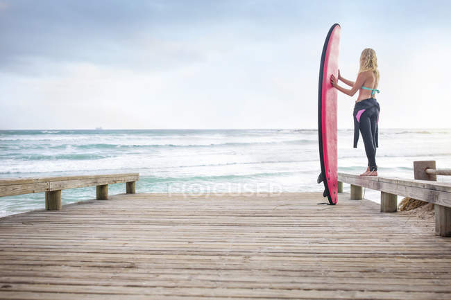 Жінка біля океану з дошки для серфінгу — стокове фото