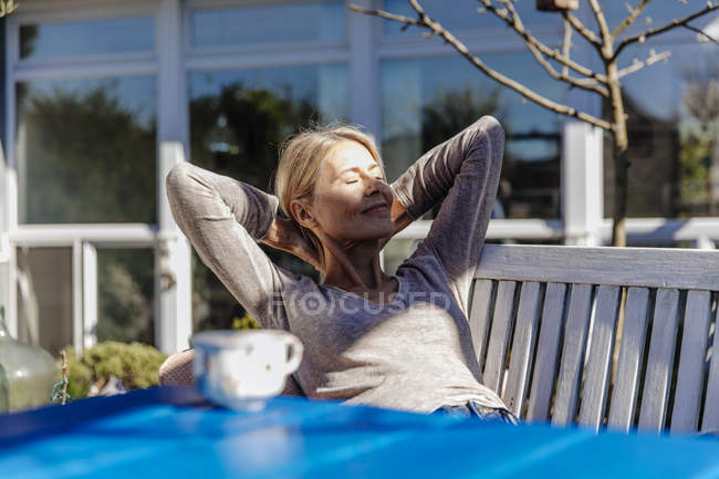 Mulher relaxante no banco de jardim — Fotografia de Stock