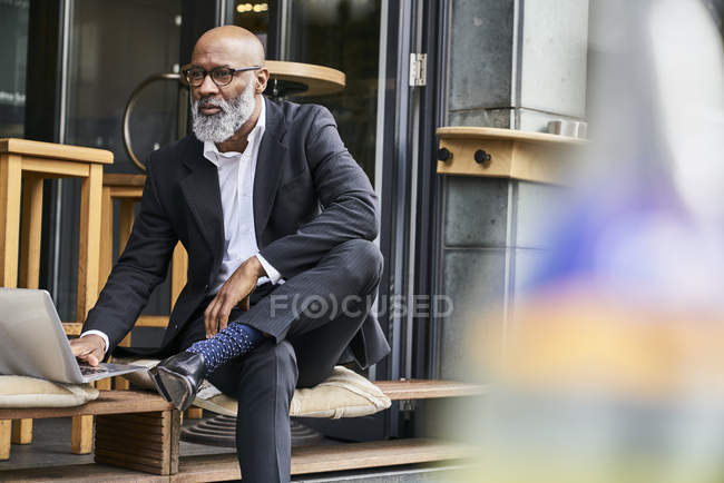 Geschäftsmann sitzt mit Laptop im Café — Stockfoto