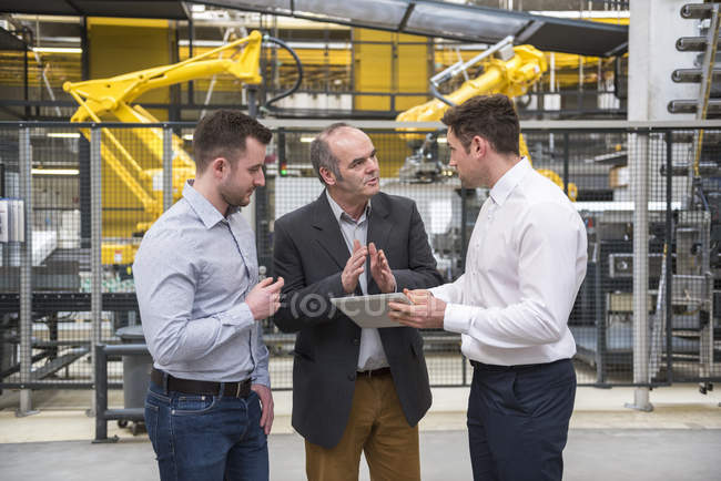 Männer mit Tablet reden in Fabrik — Stockfoto