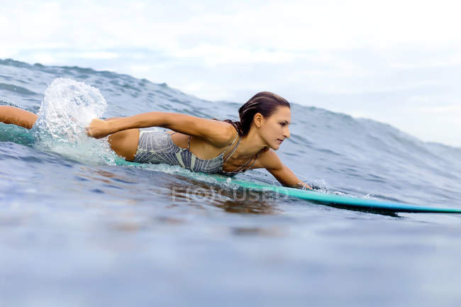 Primer plano de Chica surfeando en el océano - foto de stock