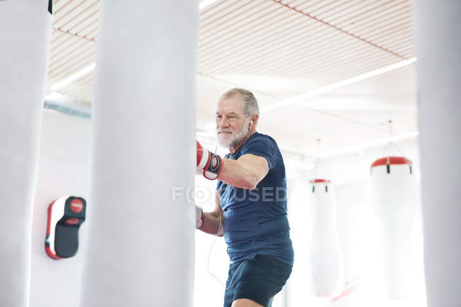 Hombre mayor perforando saco de boxeo - foto de stock