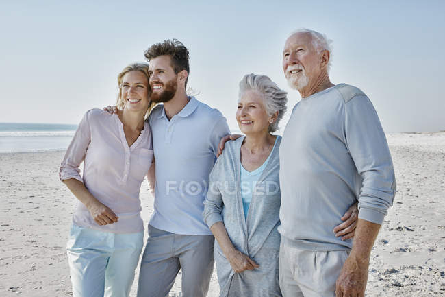 Пожилая пара с взрослыми детьми на пляже — стоковое фото