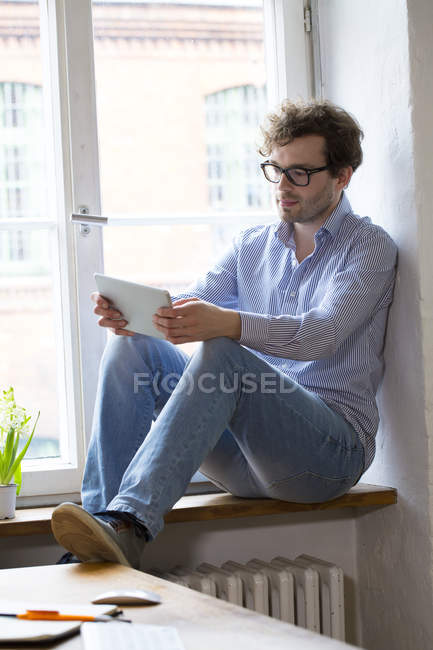 Mann benutzte Tablet am Fenster — Stockfoto