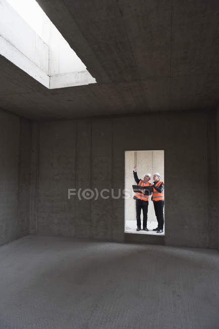 Men interacting in building under construction — Stock Photo
