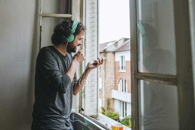 Mann telefoniert am Fenster — Stockfoto