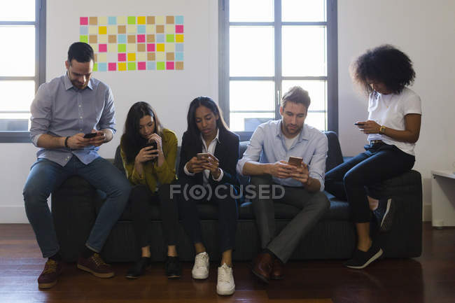 Colleagues using cell phones — Stock Photo
