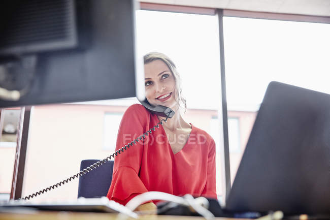 Donna al telefono in ufficio — Foto stock