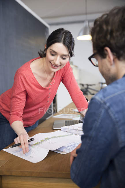 Homme et femme discutant du plan au bureau — Photo de stock