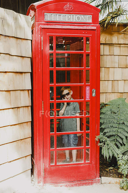 Garçon dans la cabine téléphonique rouge — Photo de stock
